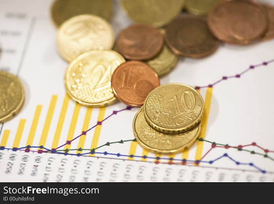 Euro coins on papers with financial data. Euro coins on papers with financial data.