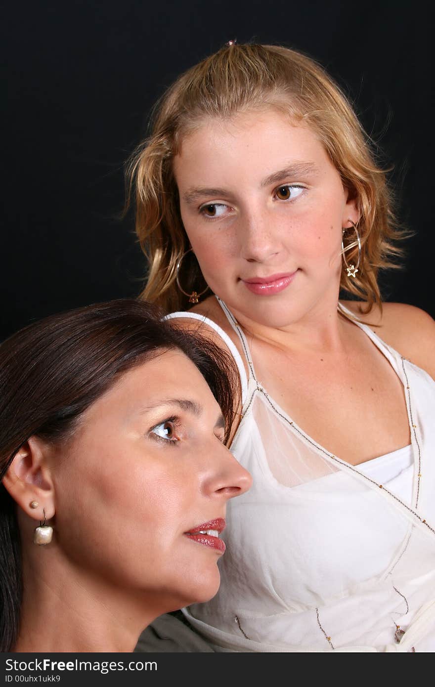 Beautiful mother and daughter on a black background