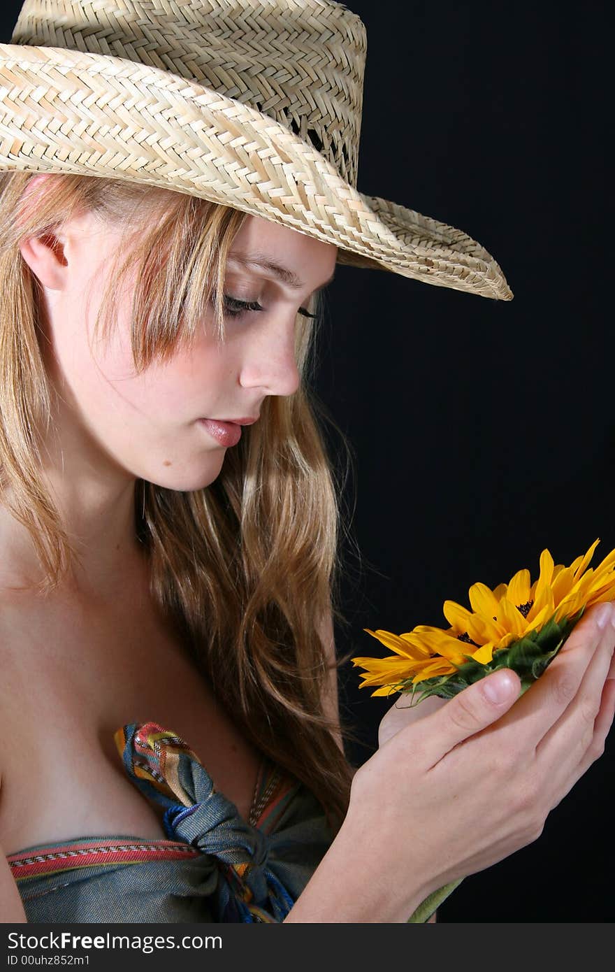 Beautiful young female model holding a sunflower