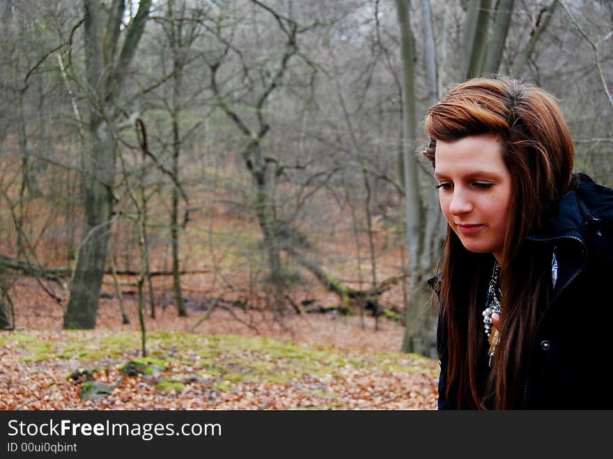 Woman walking through the forest on a cold day. Woman walking through the forest on a cold day.