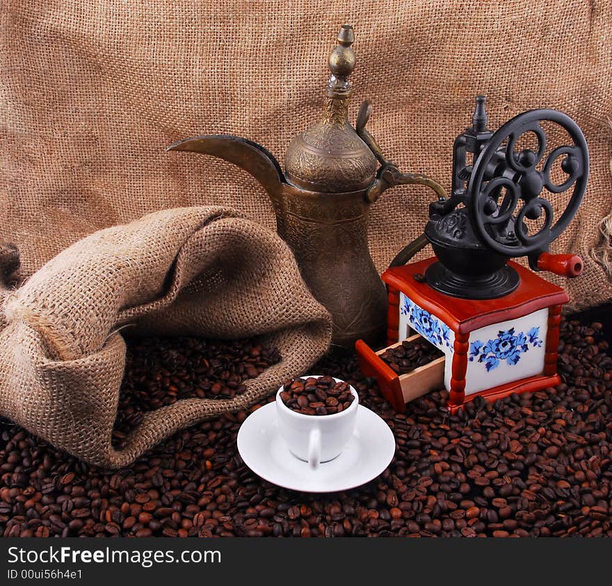 Fried coffee beans with a cup of coffee on top