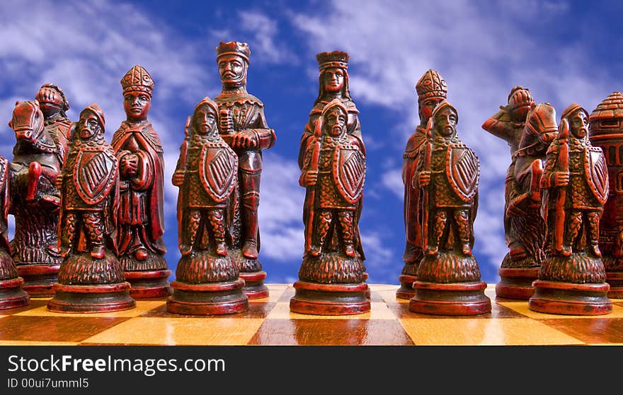 Red chess pieces pictured against a cloudy sky. Red chess pieces pictured against a cloudy sky