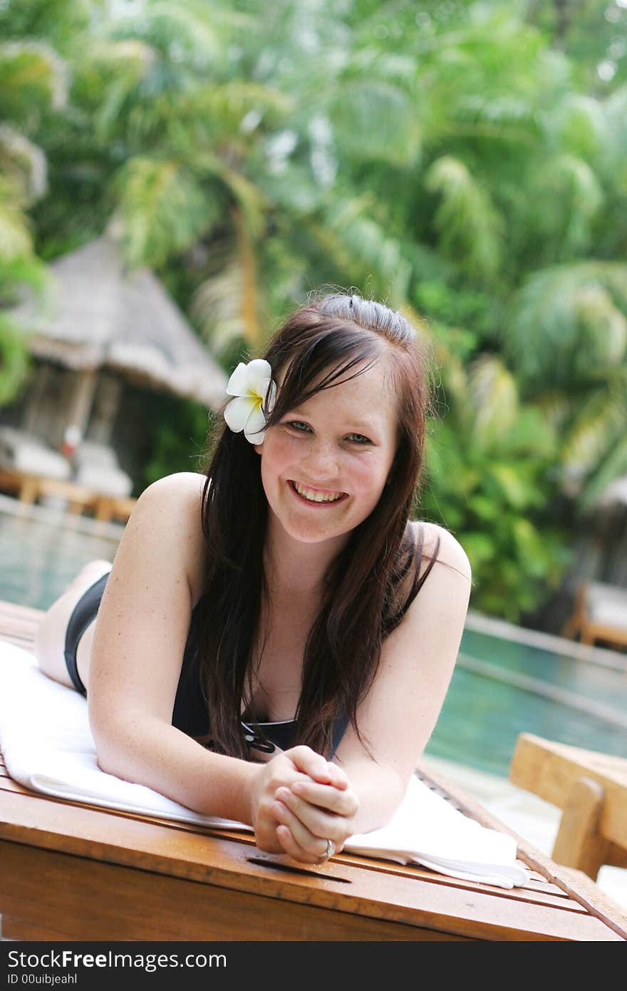 Woman in bikini relaxing on a deck chair.