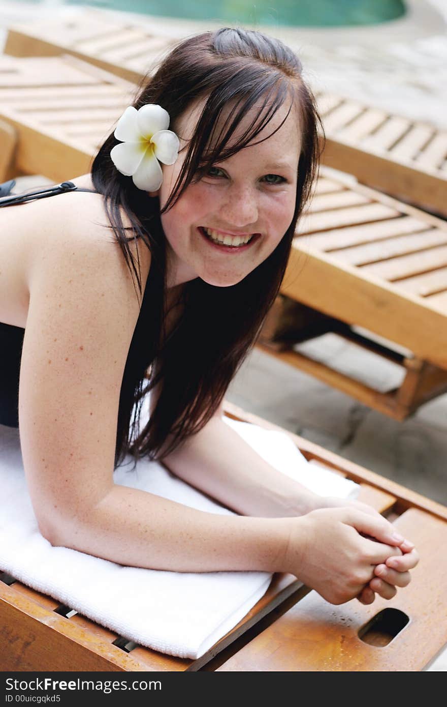 Woman in bikini relaxing on a deck chair.