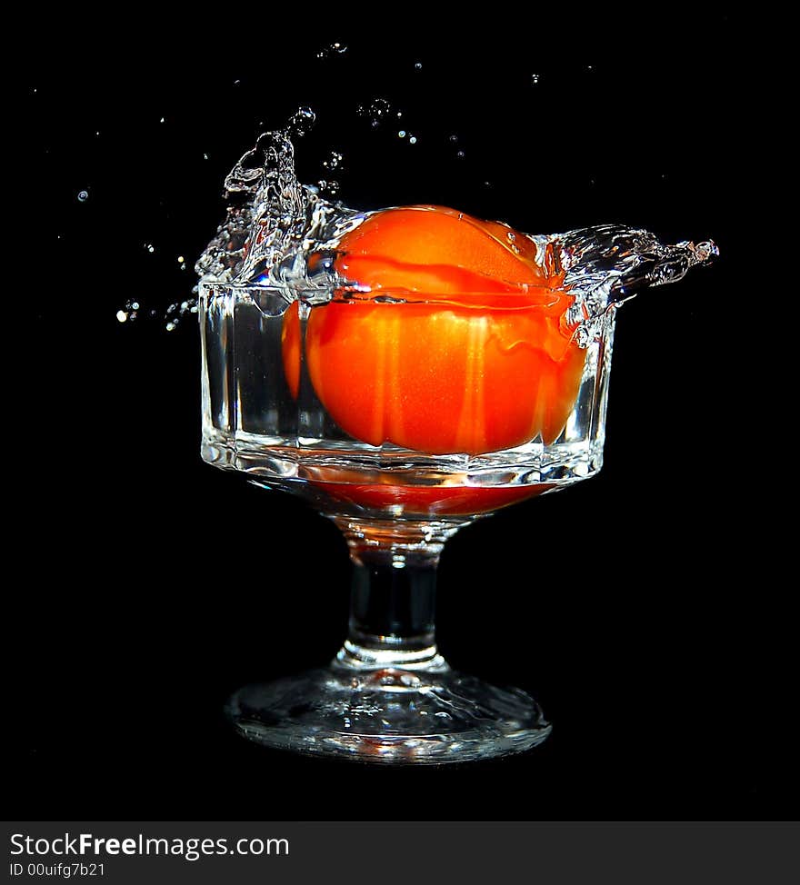 A tomato splashing into water creating a fruitful burst of energy.