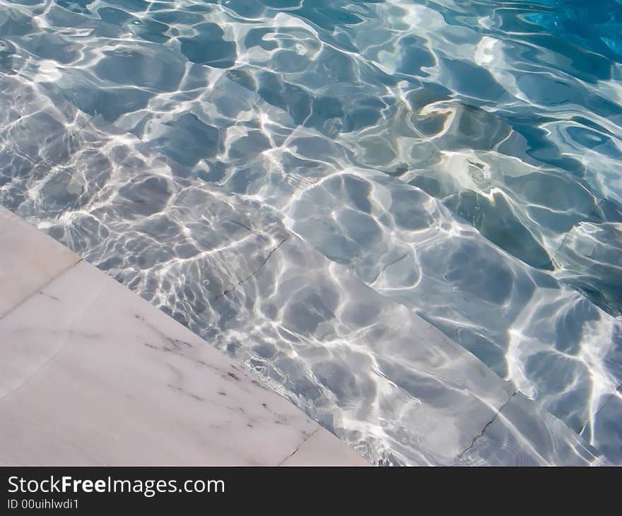 Abstract background with blue water and stairs of the swimming pool