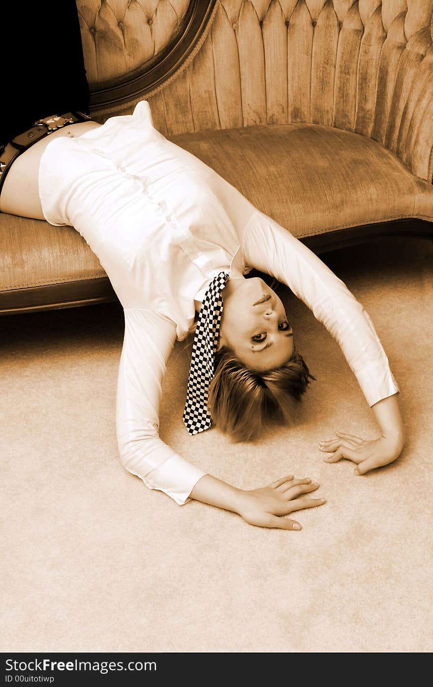 An pretty young girl in a white blouse and black and white tie lying on a pink
sofa whit her head down. An pretty young girl in a white blouse and black and white tie lying on a pink
sofa whit her head down