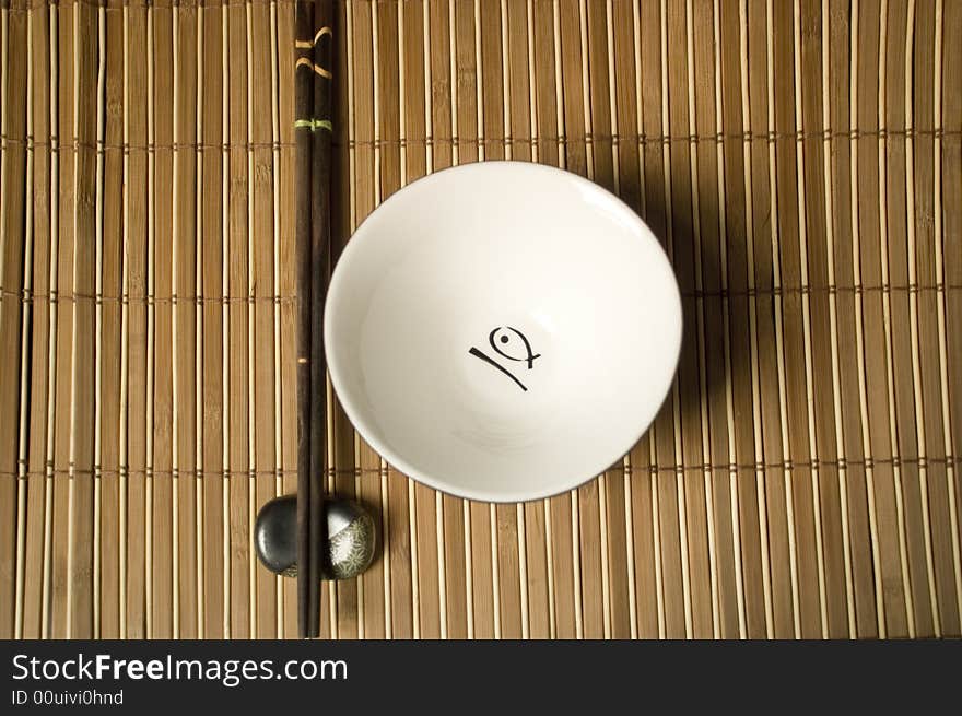 Japanese or chinese place-mat with white bowl and sticks. Japanese or chinese place-mat with white bowl and sticks