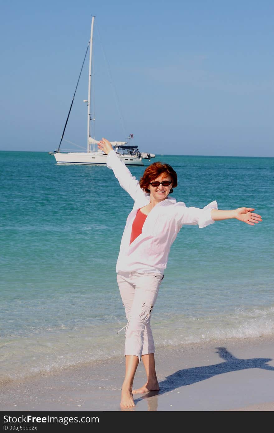 Girl posing on the beach in front of sail boat