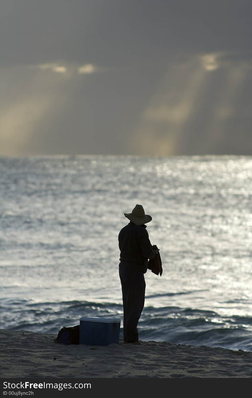 The man is fishing at the beach. The man is fishing at the beach