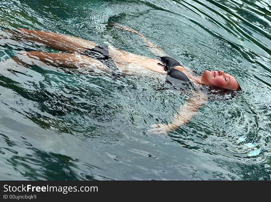 Woman floating in the water with her eyes closed. Woman floating in the water with her eyes closed.