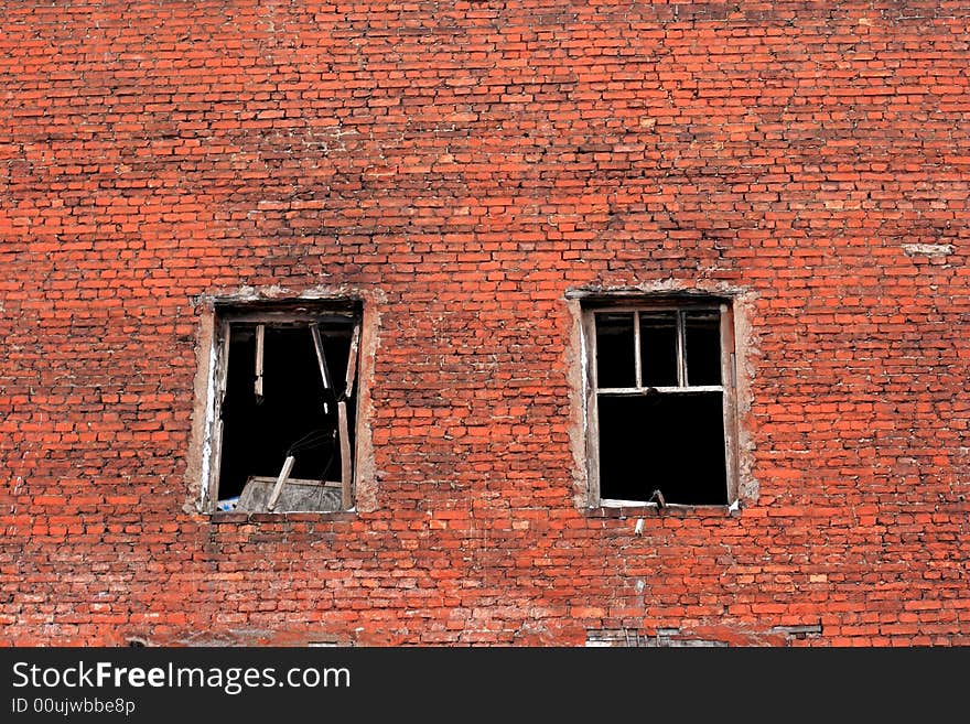 Old urban brick wall with destroyed windows