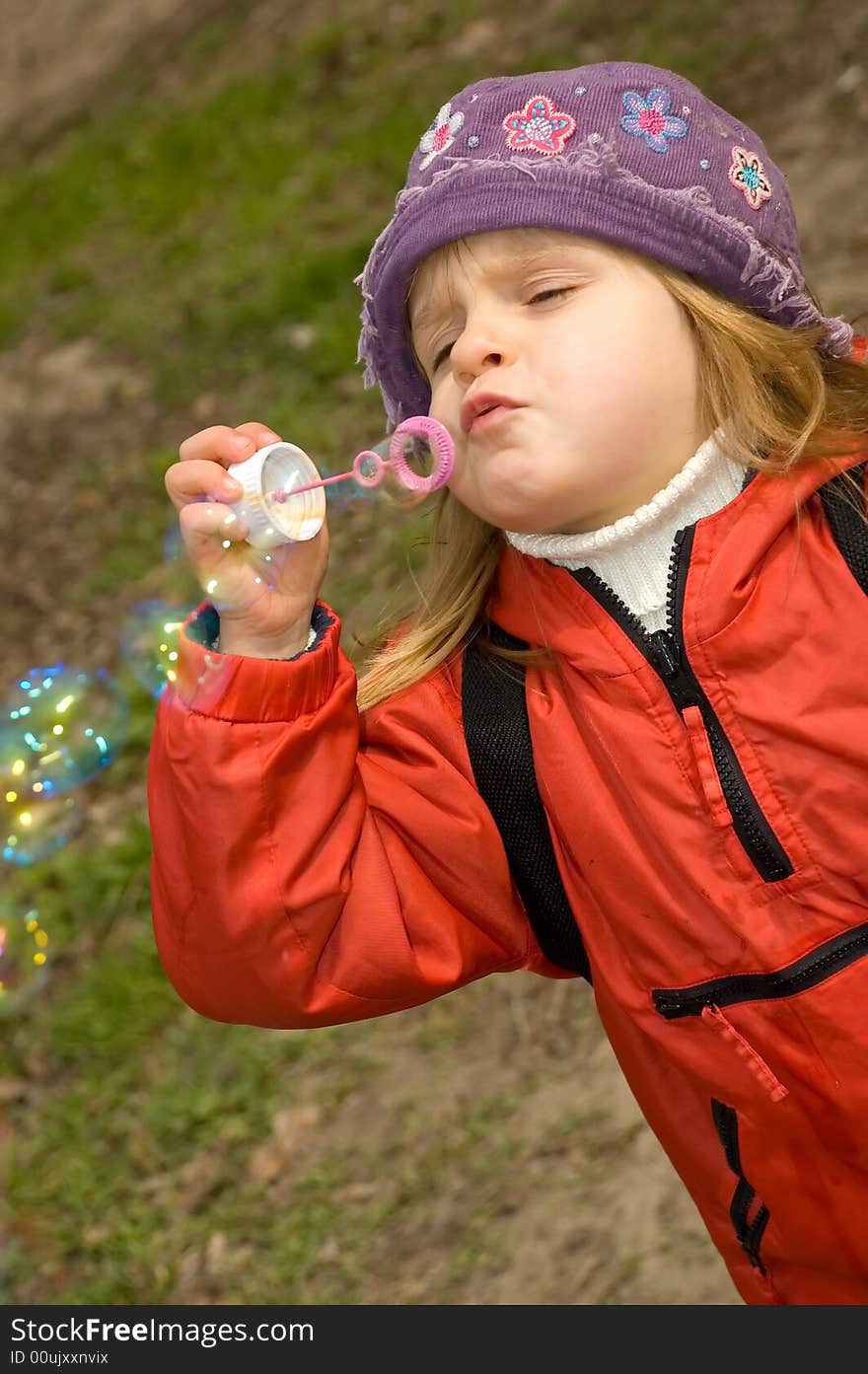 Kid is blowing soap bubbles in the park. Kid is blowing soap bubbles in the park