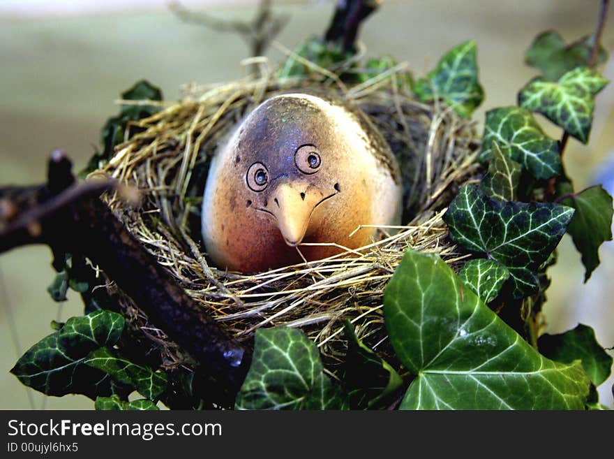 Ceramic bird in a stylized nest. Ceramic bird in a stylized nest