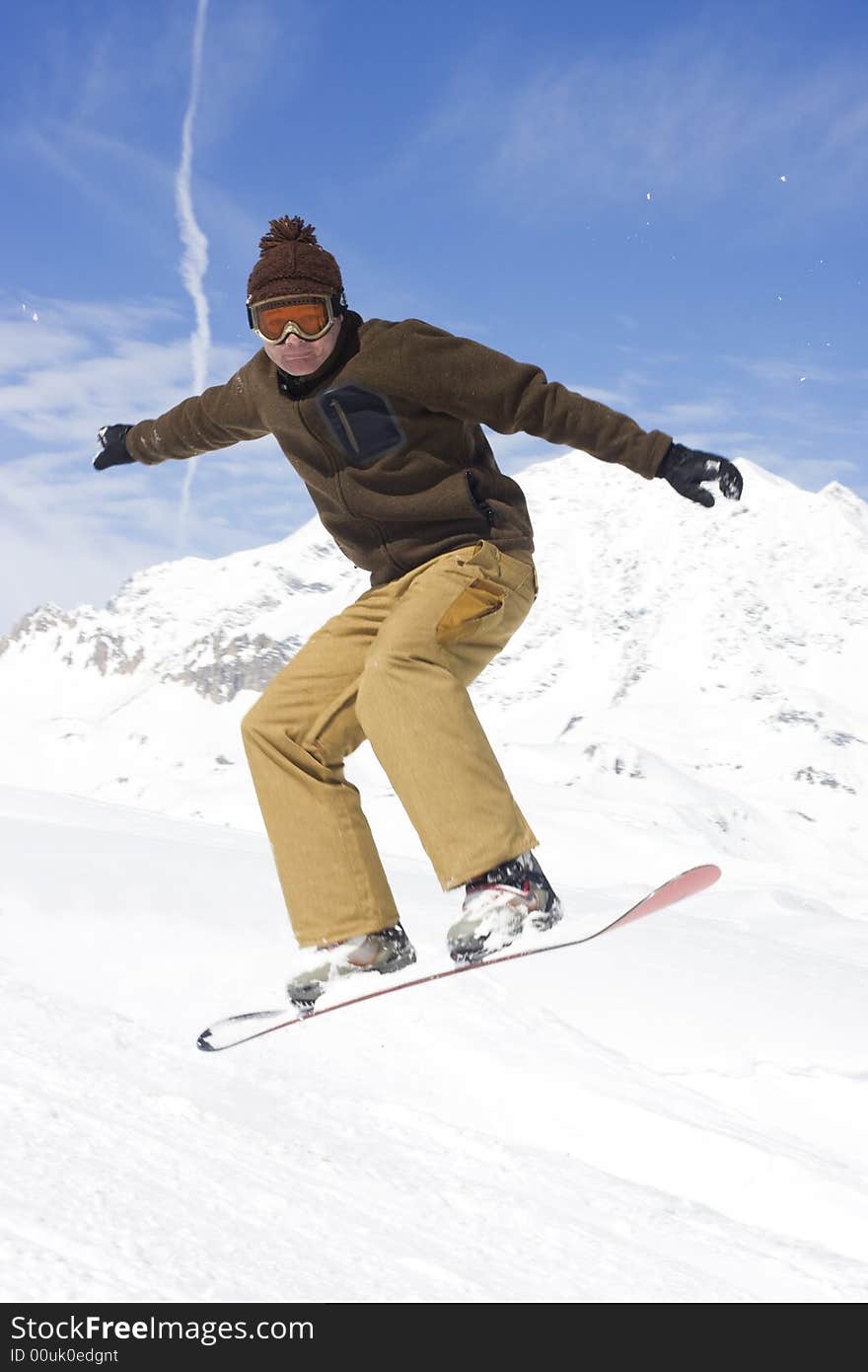 Snowboarder taking a jump in fresh snow