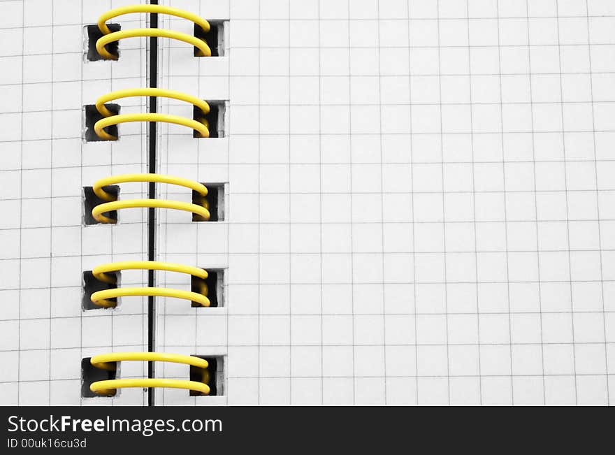 Close up of a spiral bound notebook with yellow spirals