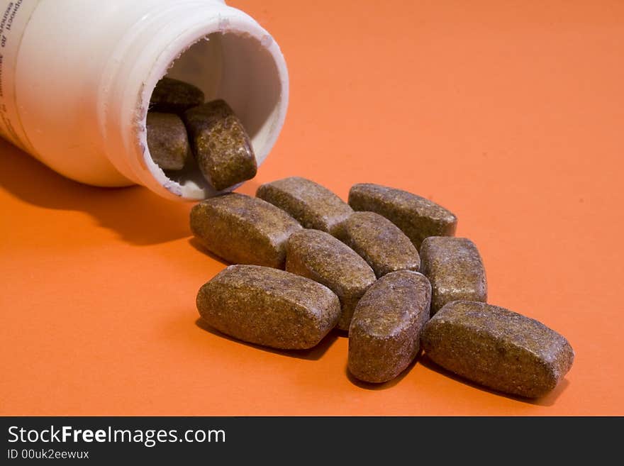 Jar with pills on an orange background