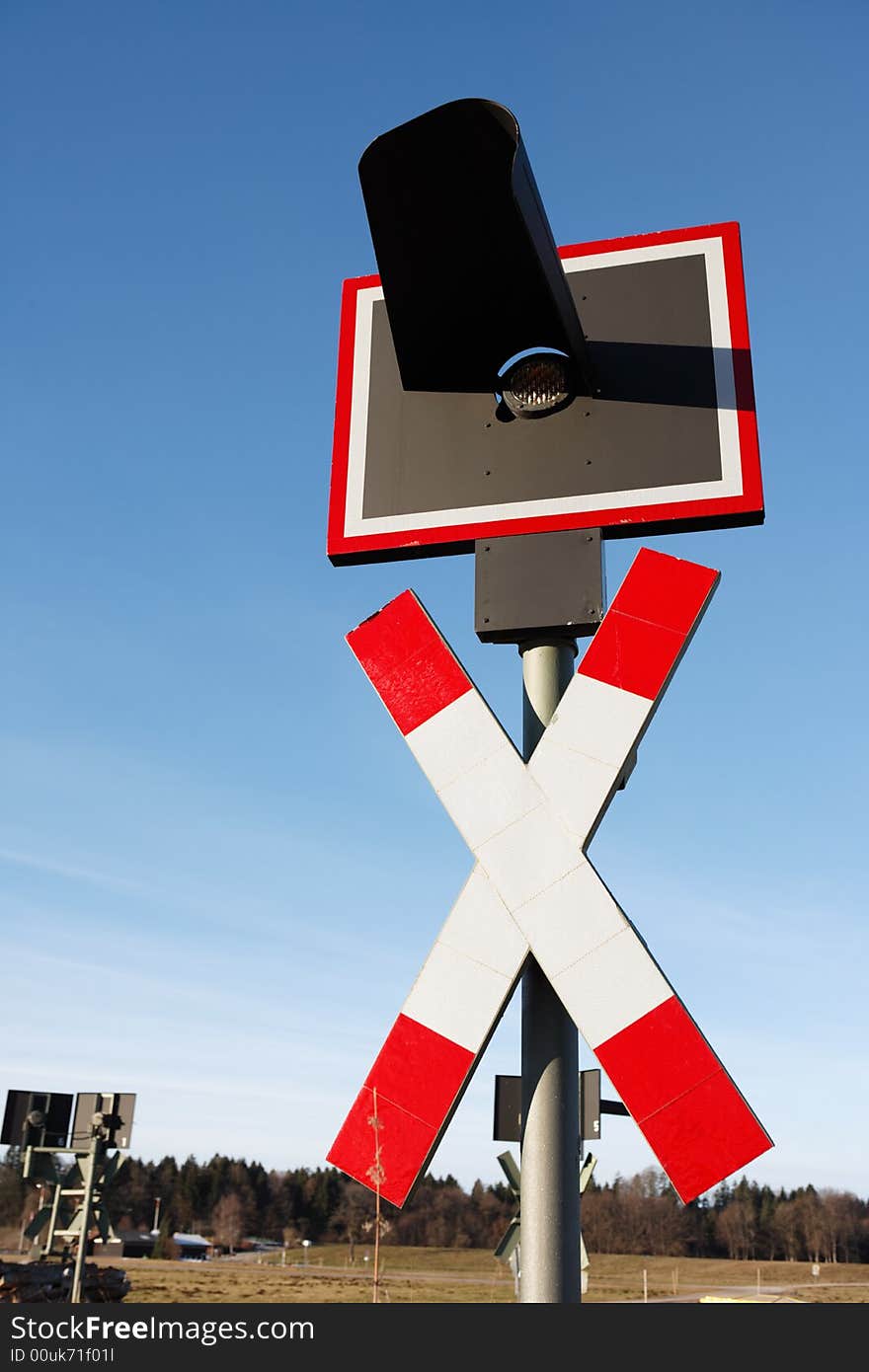 Railroad crossing sign vertical against blue sky