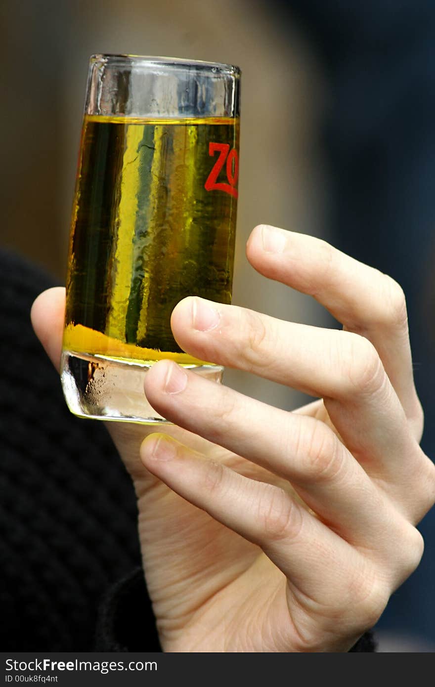 An image aof a hand taking a glass with a green drink. An image aof a hand taking a glass with a green drink