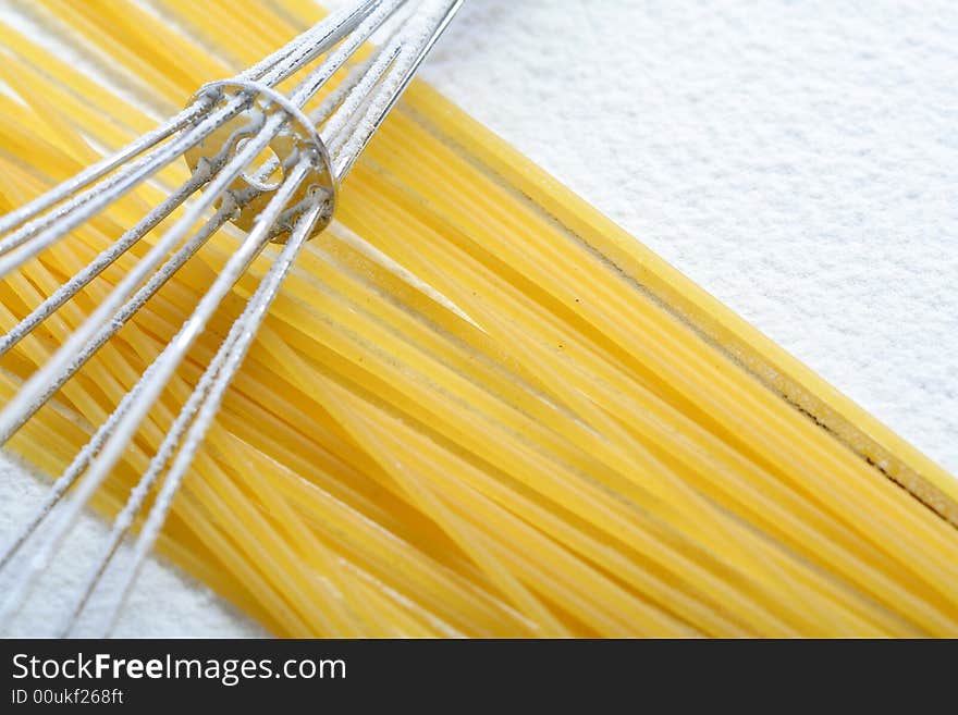 Wire Whisk And Spaghetti On Flour