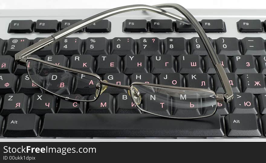 The computer keyboard and glasses