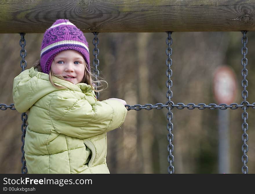 Little girl climbing on chains. Little girl climbing on chains