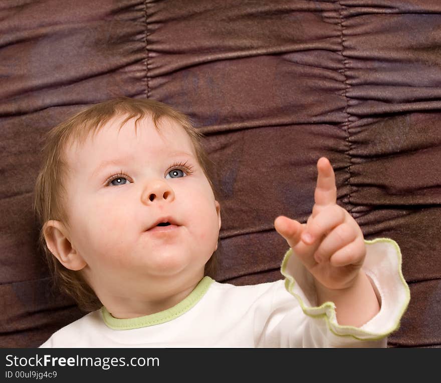 Portrait of the little girl on a brown background