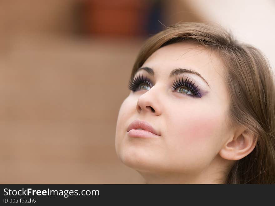 Sight of the young beautiful woman at a brown background