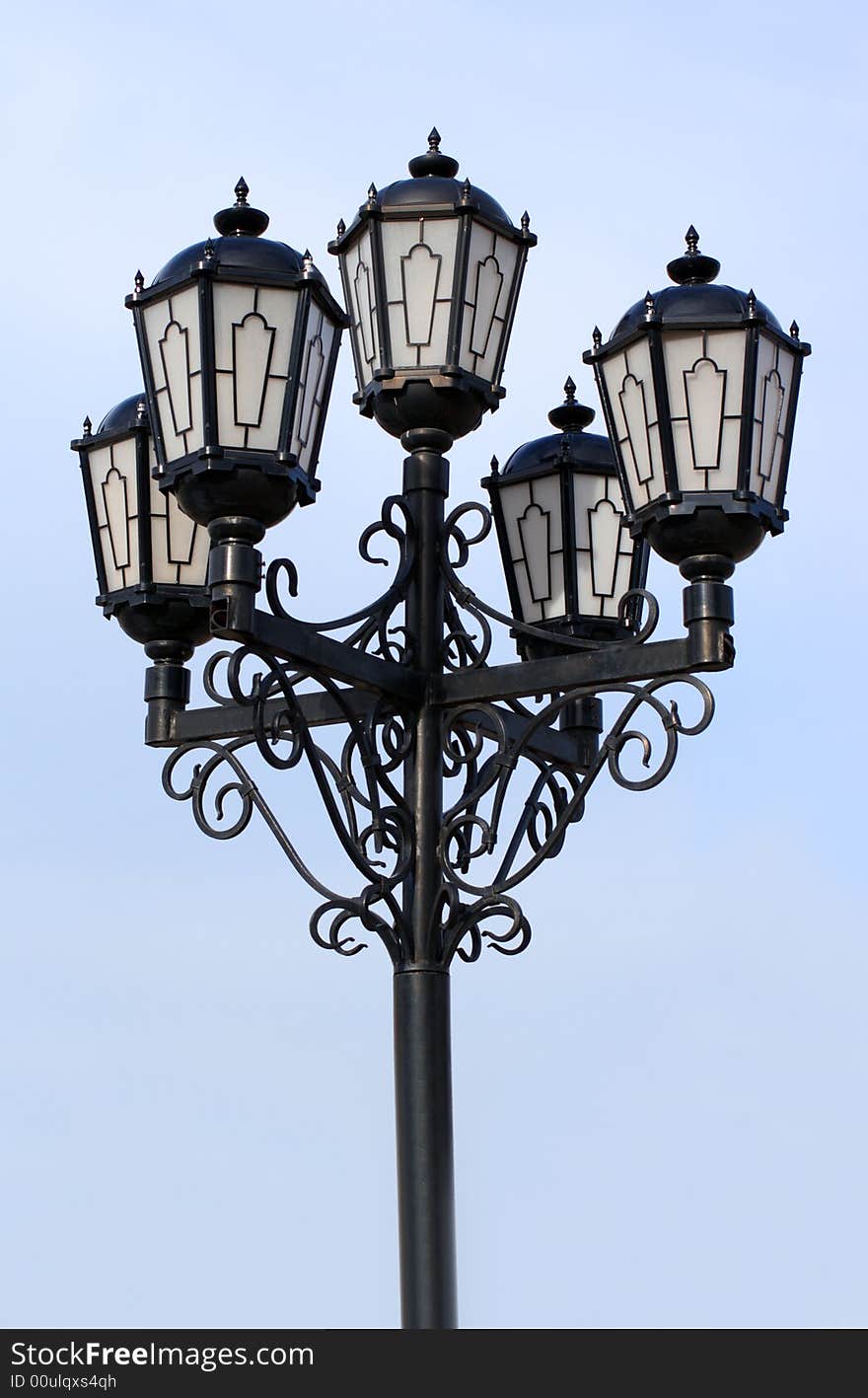 Old black street lamp under blue sky