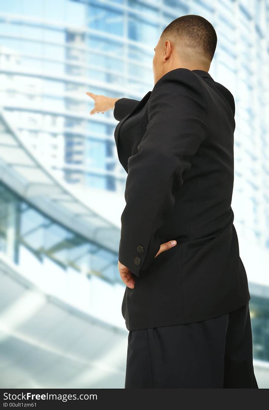 A business man pointing at modern building outdoor in downtown area. A business man pointing at modern building outdoor in downtown area