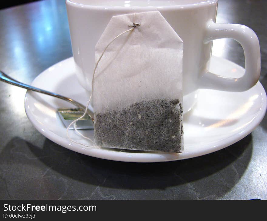 Packet of tea beside white ceramic cup