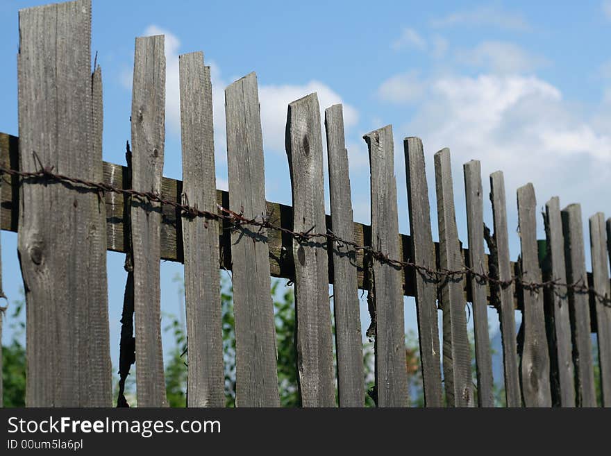 Old Wood Fence over a blue sky with clouds