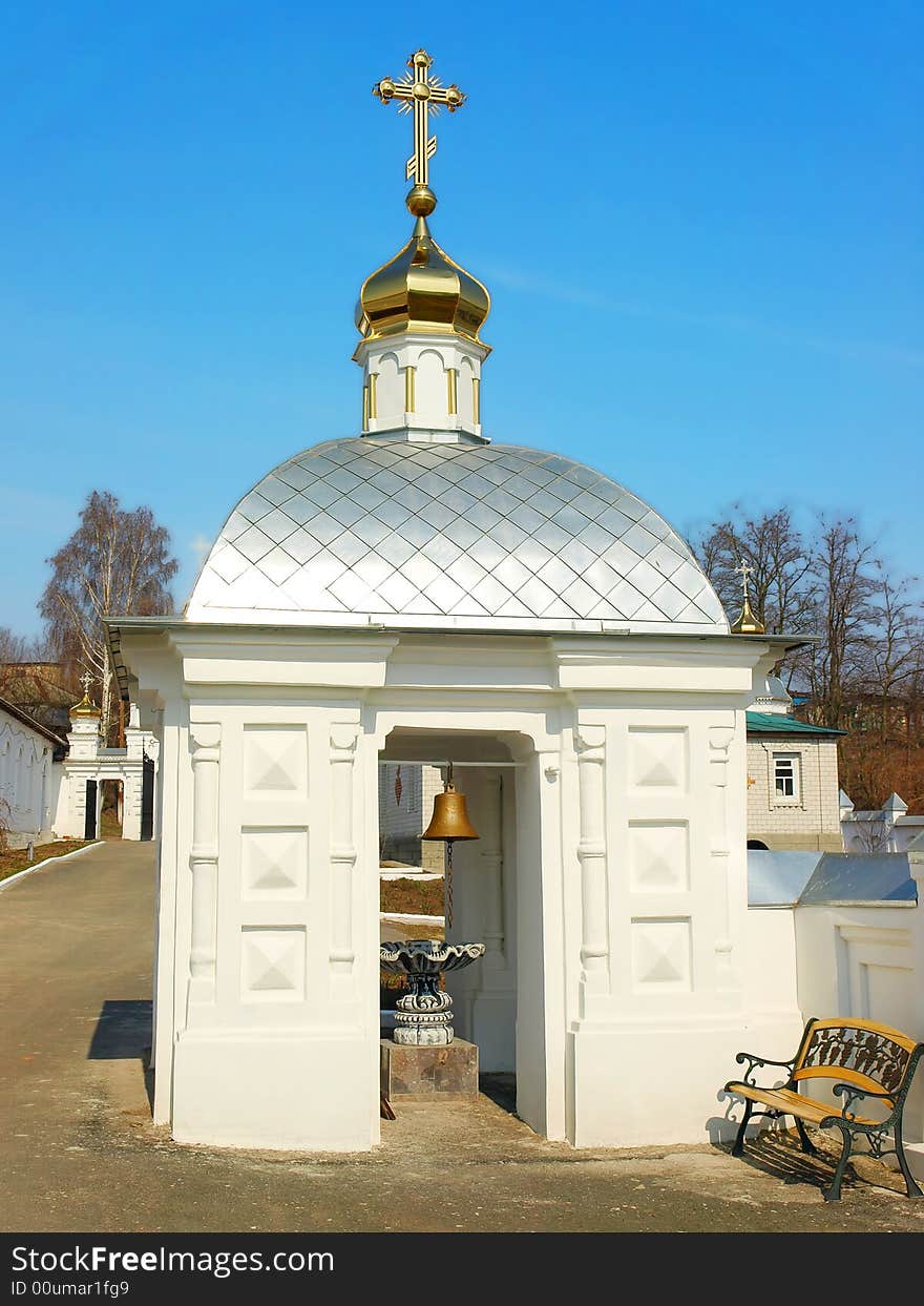 Little white belfry with the golden dome