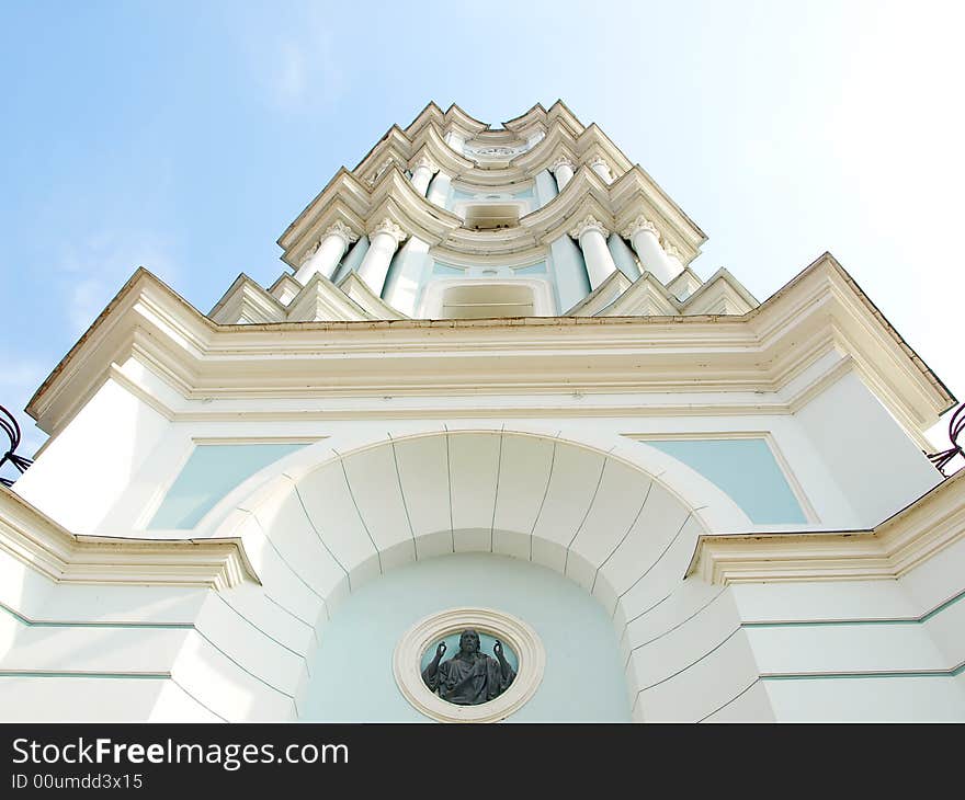 Tall white church tower with the blue sky