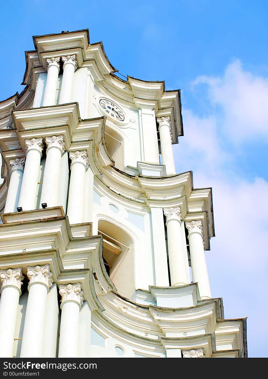 Tall white church tower with the blue sky