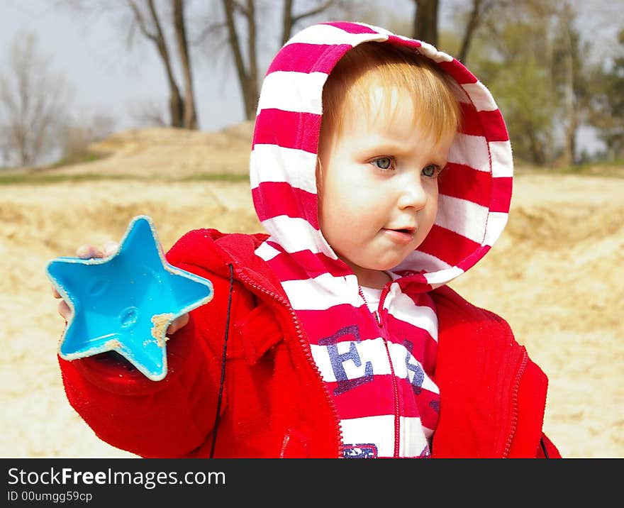 Little girl plays with sand