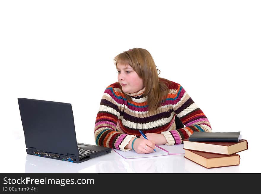 Teenage student girl doing schoolwork with laptop and books at desk, white background, reflective surface, studio shot,. Teenage student girl doing schoolwork with laptop and books at desk, white background, reflective surface, studio shot,