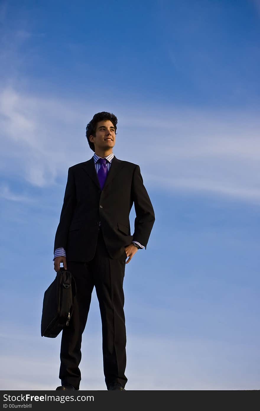 Businessman posing against blue sky. Businessman posing against blue sky.