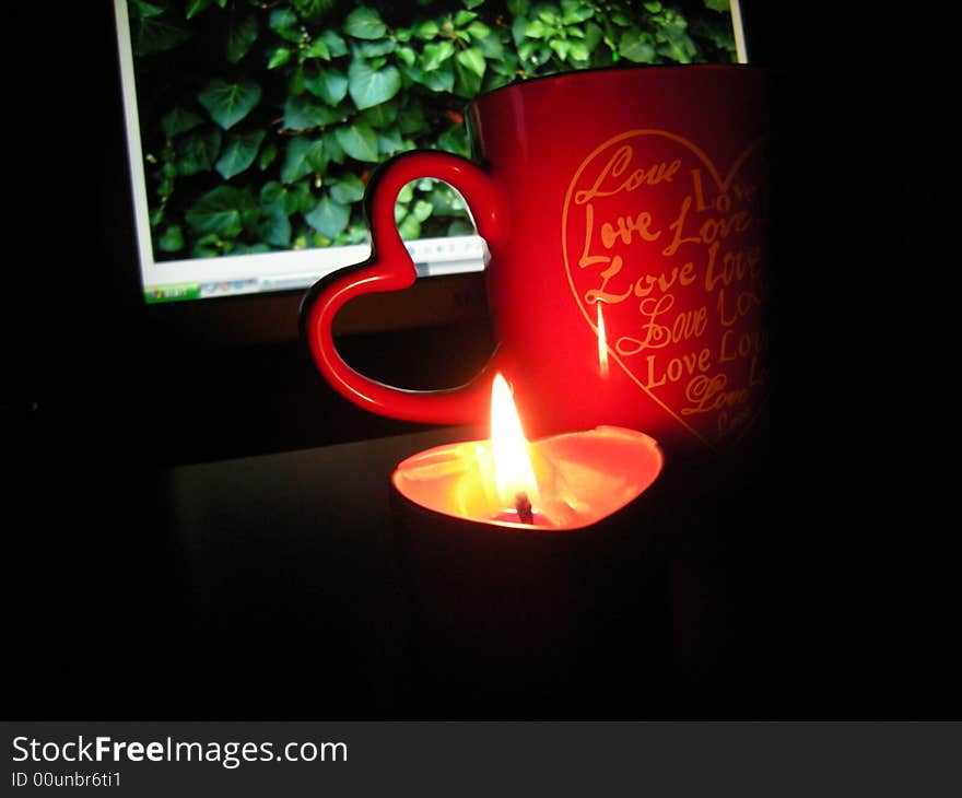 Cup of coffe - heart candle and monitor on black background. Cup of coffe - heart candle and monitor on black background