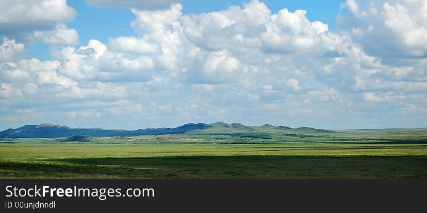 Landscape - green filed, the blue sky and white clouds