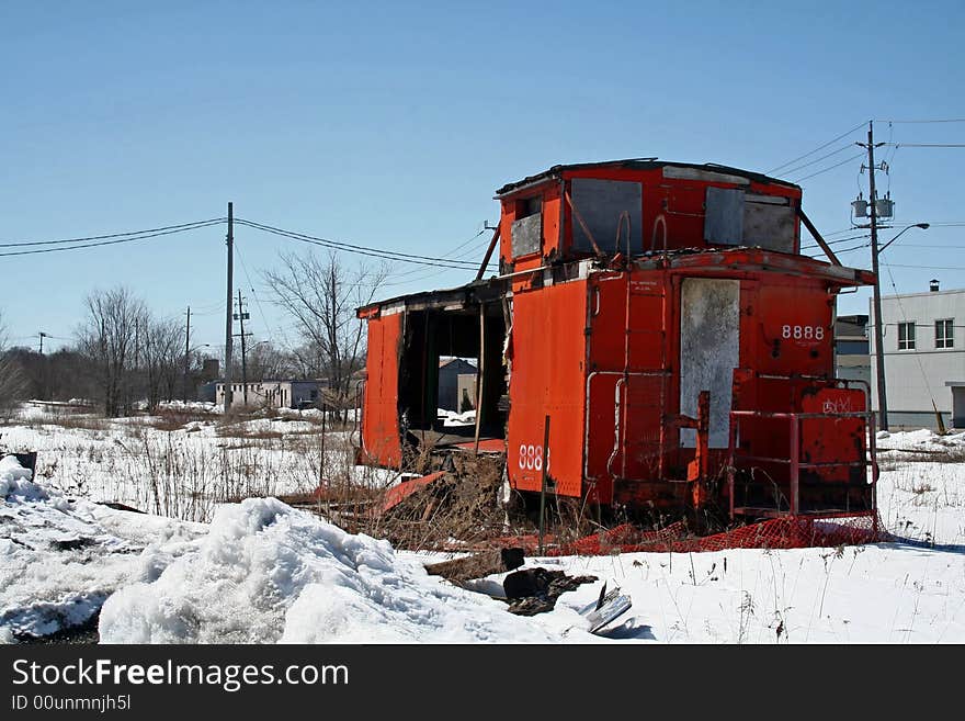 An Abandoned and burned out Caboose sitting in a field. An Abandoned and burned out Caboose sitting in a field