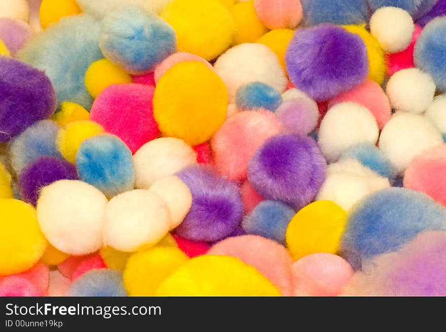 A view of an assortment of cotton balls of different sizes and bright colors. A view of an assortment of cotton balls of different sizes and bright colors.