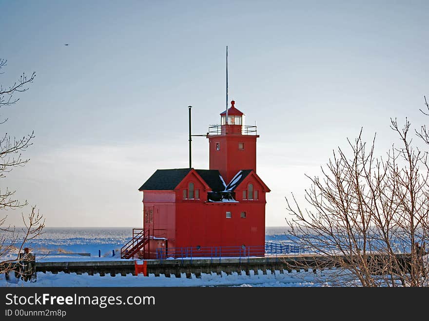 Bright red lighthouse in the frozen harbor.