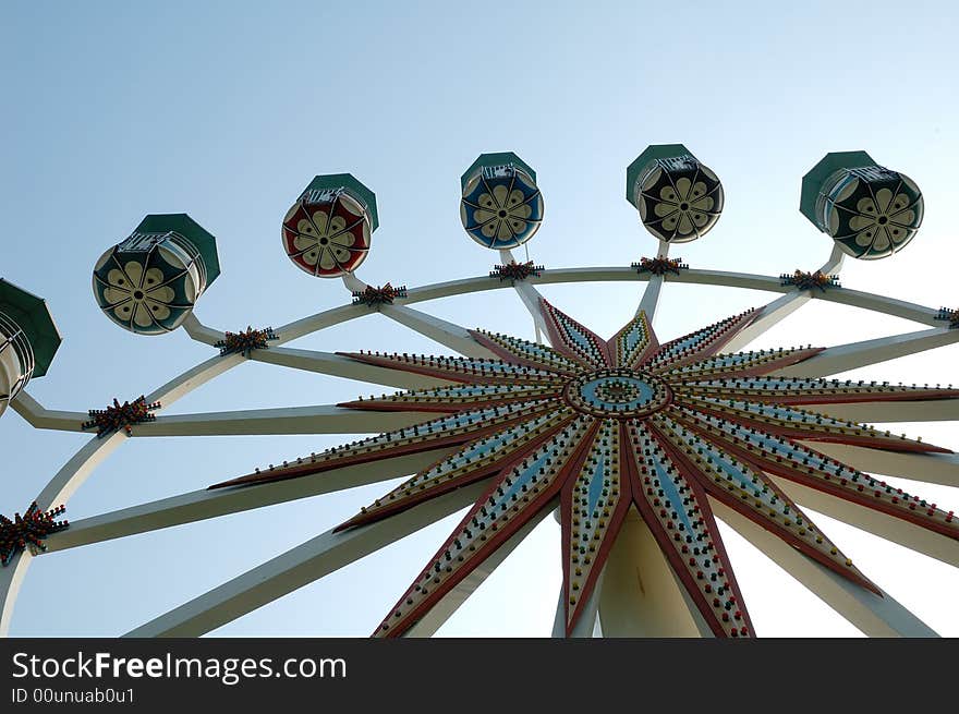 Ferris wheel on a blue sky background.