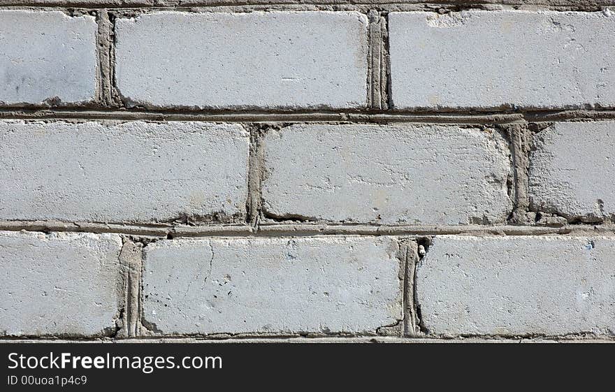 Old gray brick wall. White (in past) silicate bricks like background.