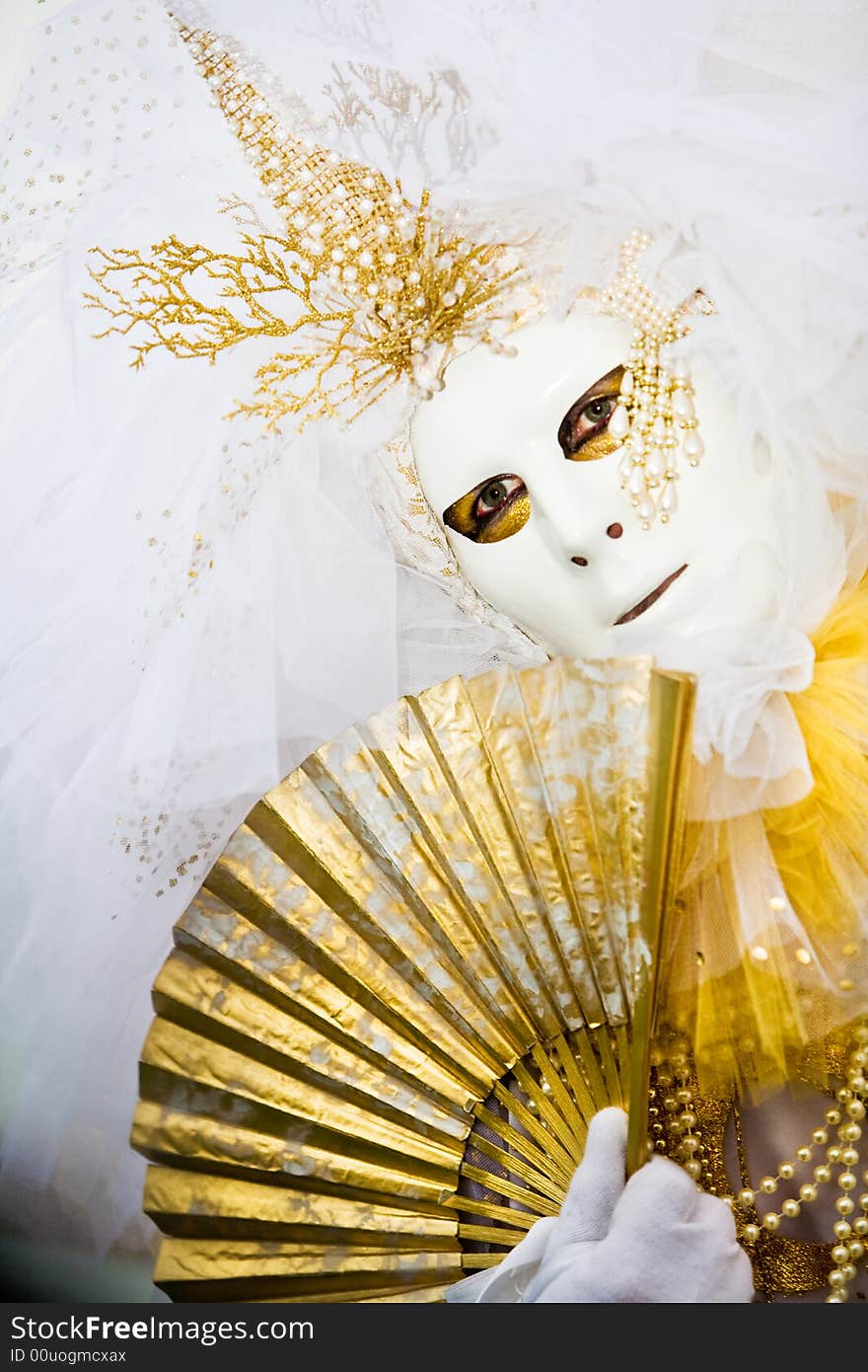 White costume and gold mask at the Venice Carnival. White costume and gold mask at the Venice Carnival