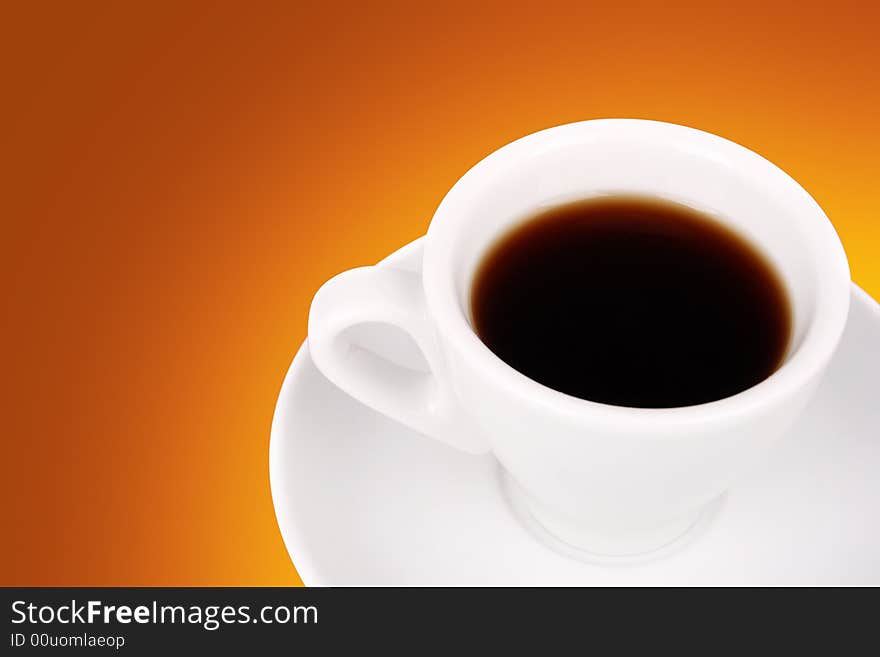 White cup of coffee over orange background