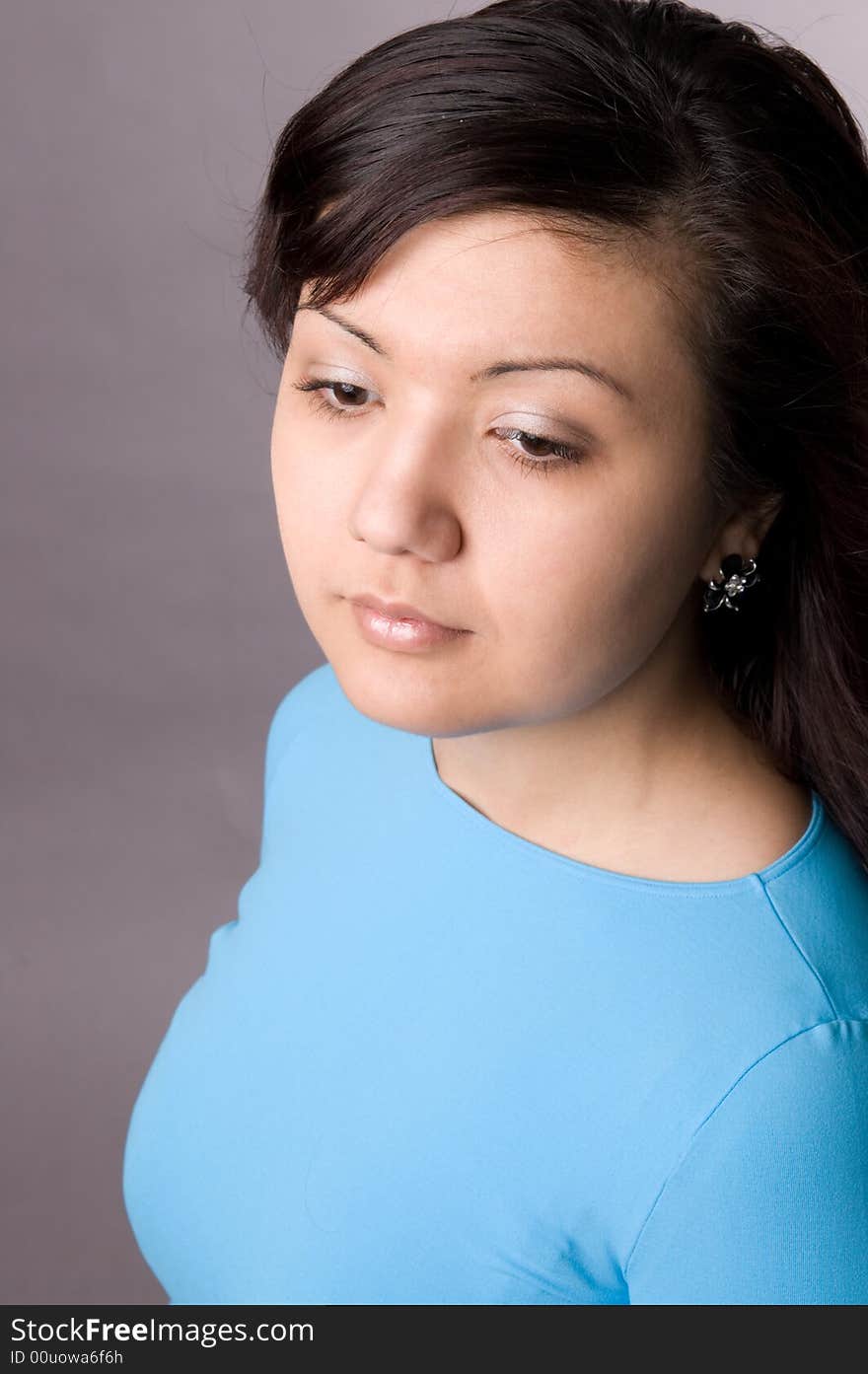 Multi-ethnic girl in studio on grey background.