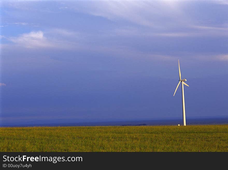 Wind turbine silhouette in meadow