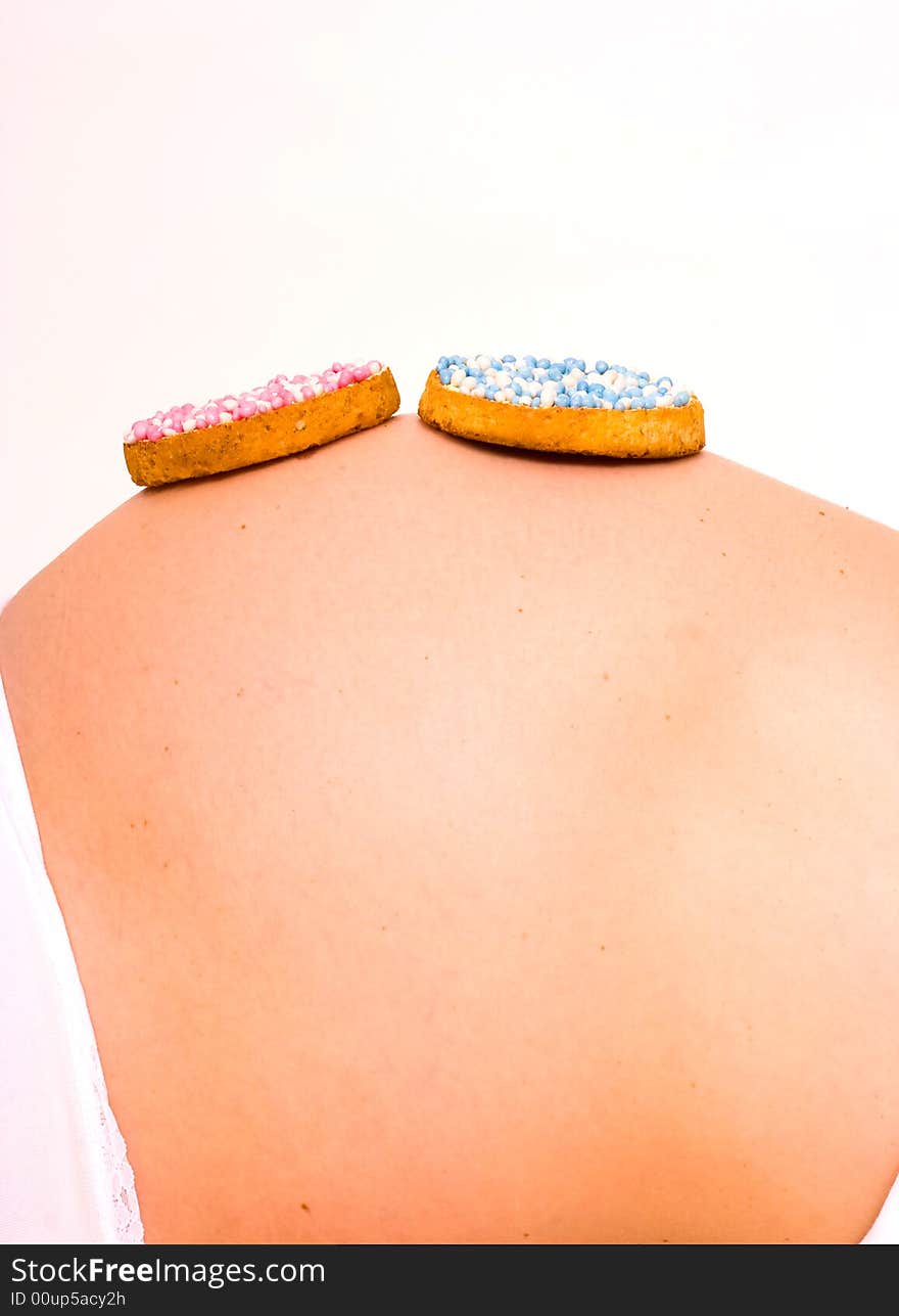 A biscuit with blue and pink candy on pregnant stomach. What will it be?. A biscuit with blue and pink candy on pregnant stomach. What will it be?